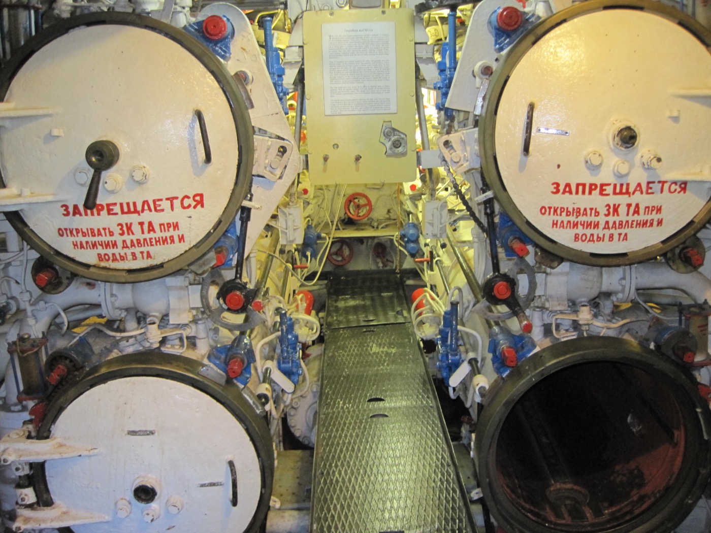 Forward torpedo tubes aboard a Foxtrot-class submarine, showing two open breech doors with Russian warning text reading 'Do not open when pressure or water is in the tube'