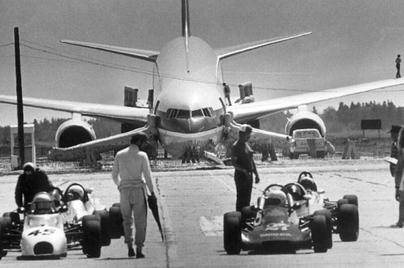 C-GAUN nose-down on the Gimli runway with race cars in the foreground, 1983